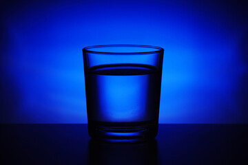 A glass with water at blue background