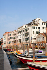 Beautiful view on Venice canal with colorful boats and old buildings in Italy in sunny day