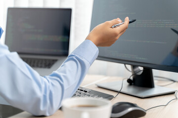 Programming developing software application. programmer writing program code with two monitors and...
