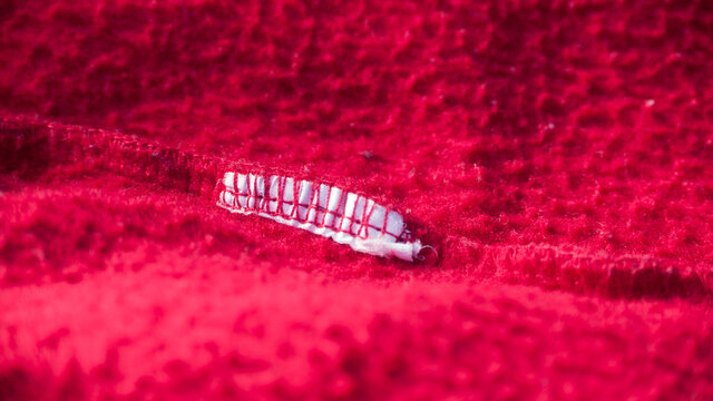 Resto de etiqueta en pespunte de hilo rojo en interior de pantal&oacute;n de ch&aacute;ndal de algod&oacute;n rojo