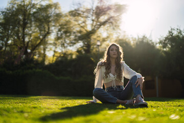 Chica joven guapa en parque disfrutando de un espacio verde en primavera