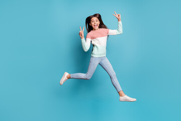 Fototapeta na wymiar Full body photo of young excited girl happy positive smile go run jump show peace cool v-sign isolated over blue color background