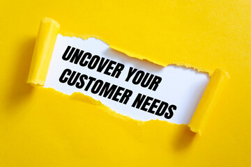 uncover your customer needs. Text on white paper on torn paper
