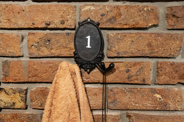the towel hangs on the wall on a curly hook. bathroom interior. cloth for wiping wet body and hands