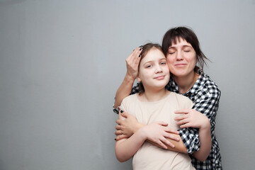Woman in   plaid shirt embracing her daughter