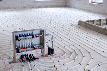 underfloor heating system - water pipes with collector on the new building floor