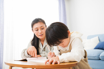 家でお母さんと一緒に勉強をする男の子