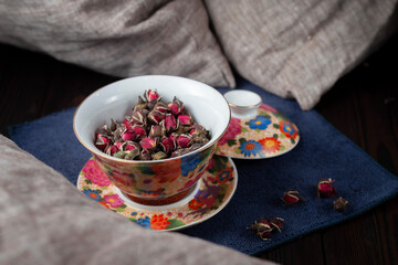 Beautiful cup with dried tea rose flowers