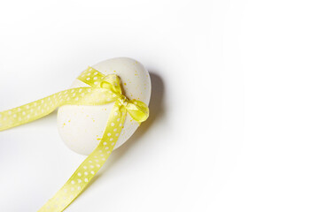 Minimal easter style design concept with creative dotted egg with yellow bow and ribbon isolated on the white background