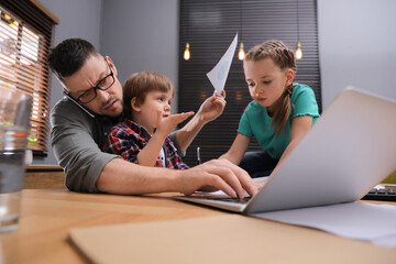 Overwhelmed man combining parenting and work at home