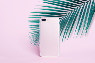 clear phone case mockup, pink smartphone iPhone 8 Plus isolated on pink background with palm leaves