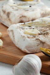 Freezer lard on a cutting board with garlic, mustard, and bay leaf