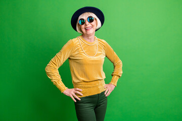 Photo of cool hipster smiling good mood old lady in hat and glasses wear yellow sweater isolated on...