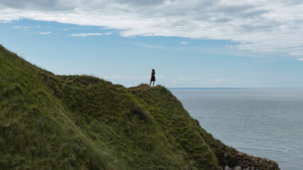 Femme posant sur une falaise