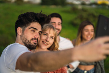 Fototapeta premium Grupo de amigos disfrutando de zona verde en primavera tomando selfies