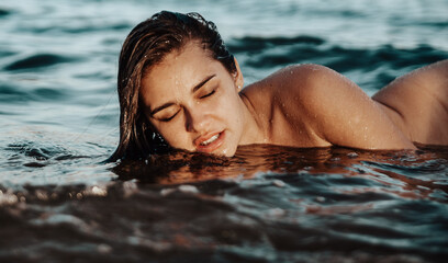 Sensual young woman posing in the water.
