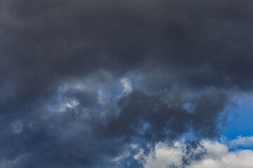 Fototapeta na wymiar Dark storm clouds on a bright blue sky. Sky patterns background 2021.