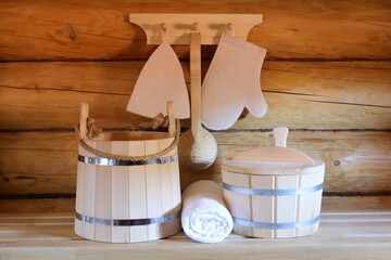 Traditional bath accessories are on a bench and hanging on the log wall in the bathhouse. 