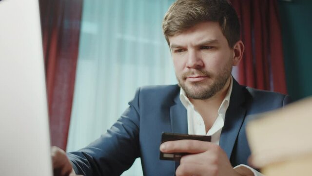 Business Concept - Portrait Handsome mature Businessman working with confident face, using credit card, entering pincode. Experienced CEO leader of the enterprise, freelancer work in home office.