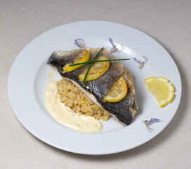 Lemon spiked sea bream fillet, cooked wheat risotto on plate