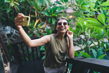 Smiling woman taking selfie on smartphone during vacation