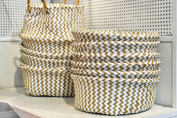 Beige Decorative wicker baskets on shelf in store. Lots of empty plastic pannier for storing...