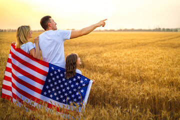 happy family with the flag of america USA at sunset outdoors 