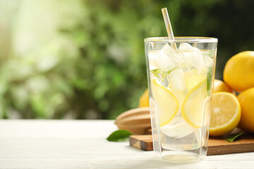 Fototapeta premium Cool freshly made lemonade and fruits on white wooden table, closeup. Space for text