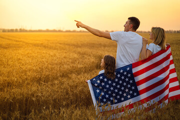 happy family with the flag of america USA at sunset outdoors 
