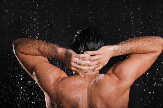 Man Washing Hair While Taking Shower On Black Background