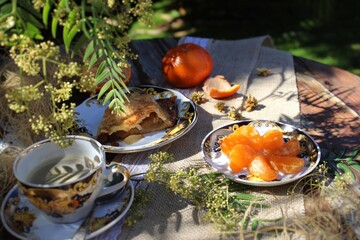 Naklejka na ściany i meble A snack with fruit pie and coffee in the garden. 
