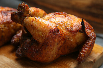 Delicious grilled whole chickens on wooden board, closeup