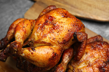 Delicious grilled whole chickens on grey table, closeup