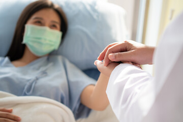 Women Asian doctors hold the patient hand and encourage and provide medical advice While checking...