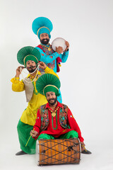 Three Bhangra Dancers playing Dafli,Dhol and Alghoza.	