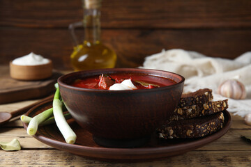 Clay bowl with Ukrainian borsch served on wooden table