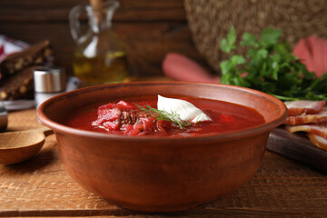 Clay bowl with Ukrainian borsch served on wooden table