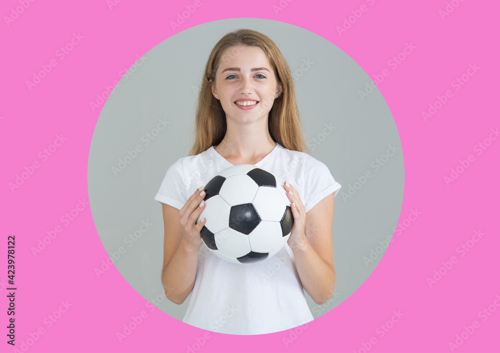 Wall mural Young woman with a soccer ball looking at the camera, on gray circle and pink background.