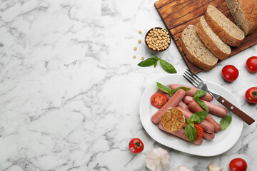Flat lay composition with vegetarian sausages and vegetables on white marble table. Space for text