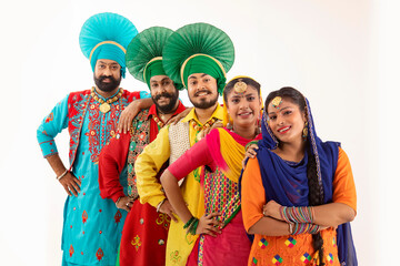 A Troupe of Punjabi Folk dancers standing together forming a vertical diagonal queue.	