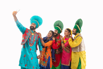A Troupe of Punjabi Folk Dancers clicking a selfie together.	