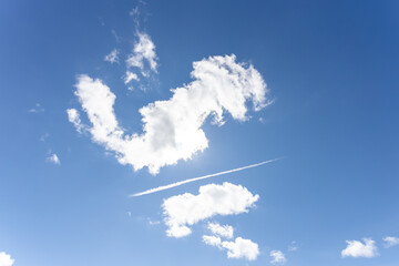 Blue sky with interesting cloud formations and vapour trail - chemtrail