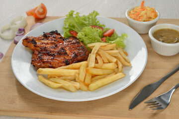 delicious plate of western food chicken chop with fries and salad