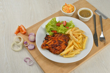 delicious plate of western food chicken chop with fries and salad