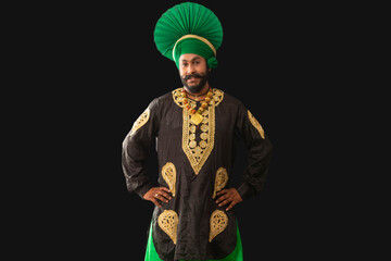 A man in Bhangra Costume standing with hands on his waist.	