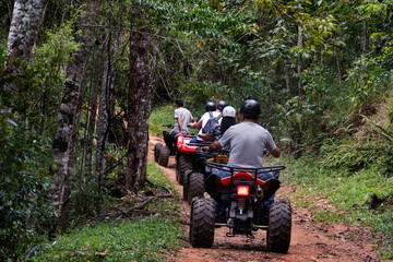 Group of people doing ATV adventure trail in the forest.