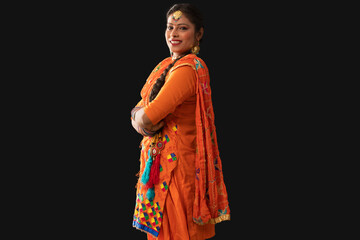 A woman in a Giddha costume standing with hands folded.	