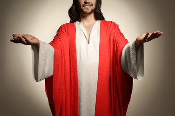 Jesus Christ with outstretched arms on beige background, closeup