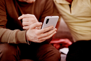 Two men look at the phone. Close up