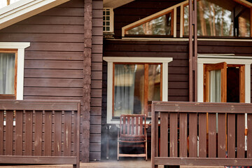 Cozy wooden house with smoke from bbq. Spring season concept
